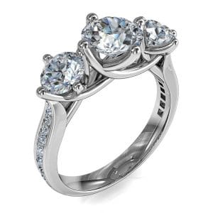 Round Brilliant Cut Diamond Trilogy Engagement Ring, Stones 4 Claw Offset on a Tapered Bead Set Band with an Undersweep Setting.